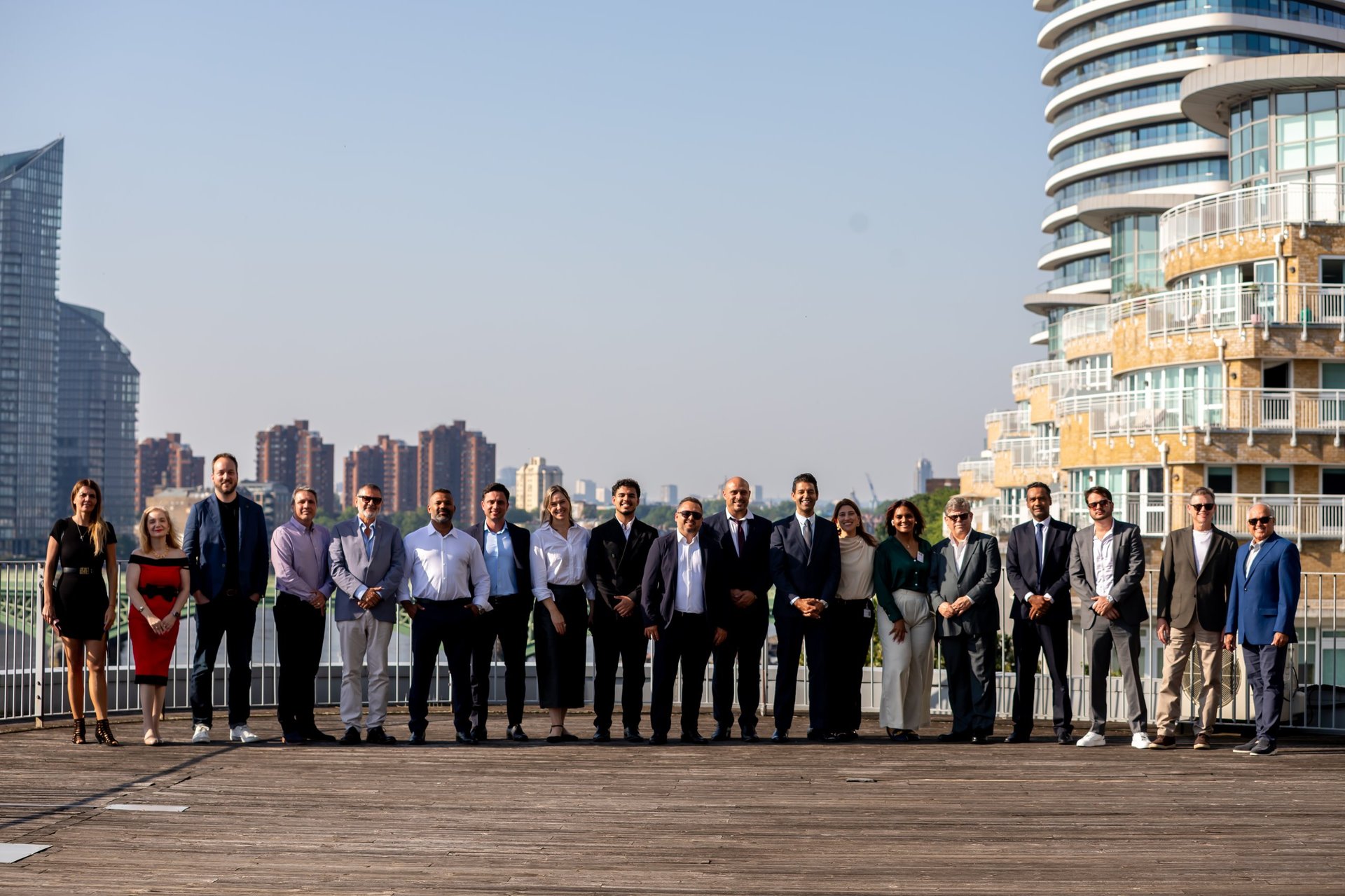 Professional group of diverse business people standing in a line on a rooftop with urban city skyline in background